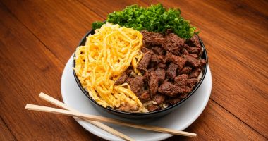Prato de sobá servido na Feira Central de Campo Grande, com macarrão, caldo, carne, omelete e cebolinha.