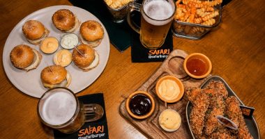 Mesa com chopp Brahma, mini burger e porções do happy hour do Safari Burger em Campo Grande.