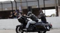 Piloto acelera motocicleta Harley-Davidson em prova de Drag Race no autódromo.