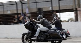Piloto acelera motocicleta Harley-Davidson em prova de Drag Race no autódromo.
