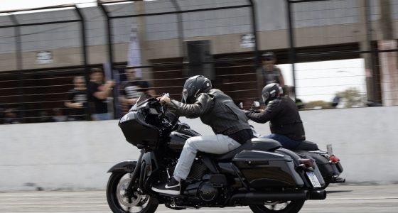 Piloto acelera motocicleta Harley-Davidson em prova de Drag Race no autódromo.