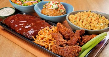 Tábua do Outback com costela, massa, carnes e acompanhamentos servida para compartilhar entre amigos ou familiares.