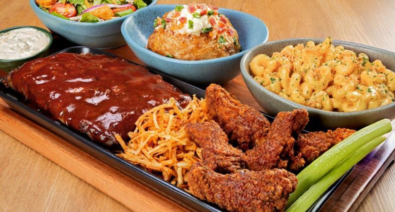 Tábua do Outback com costela, massa, carnes e acompanhamentos servida para compartilhar entre amigos ou familiares.
