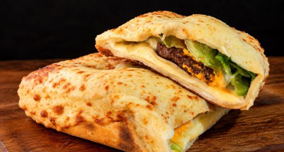 Pizza X-Burger da Fornalha Pizzaria, com dois hambúrgueres, queijo e massa de pizza, participante do Bar em Bar 2026.